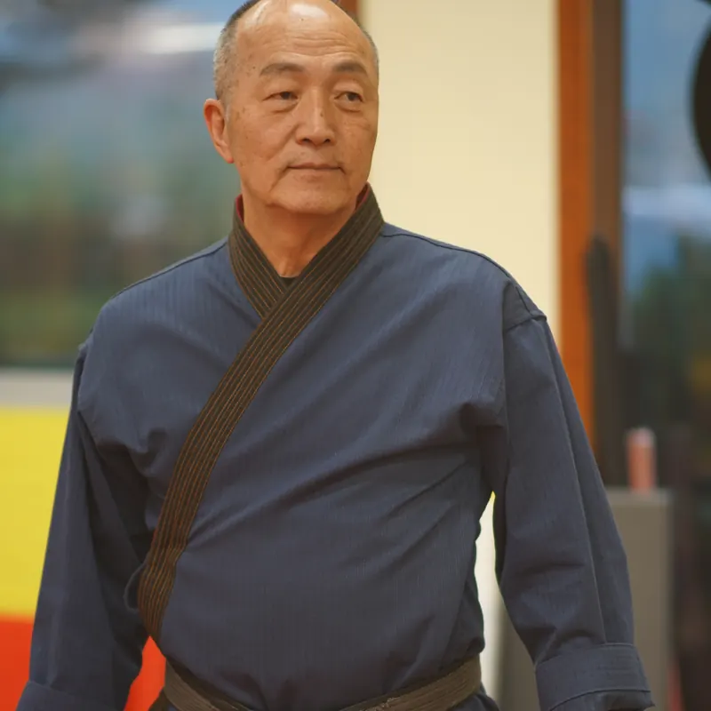 Grand Master Won Kuk Kim standing in his dobok and belt