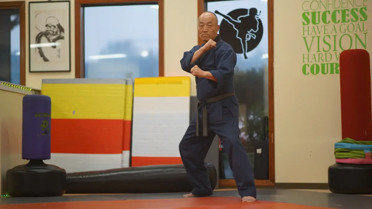 Grand Master Won Kuk Kim in a stance, with a wide view of the academy