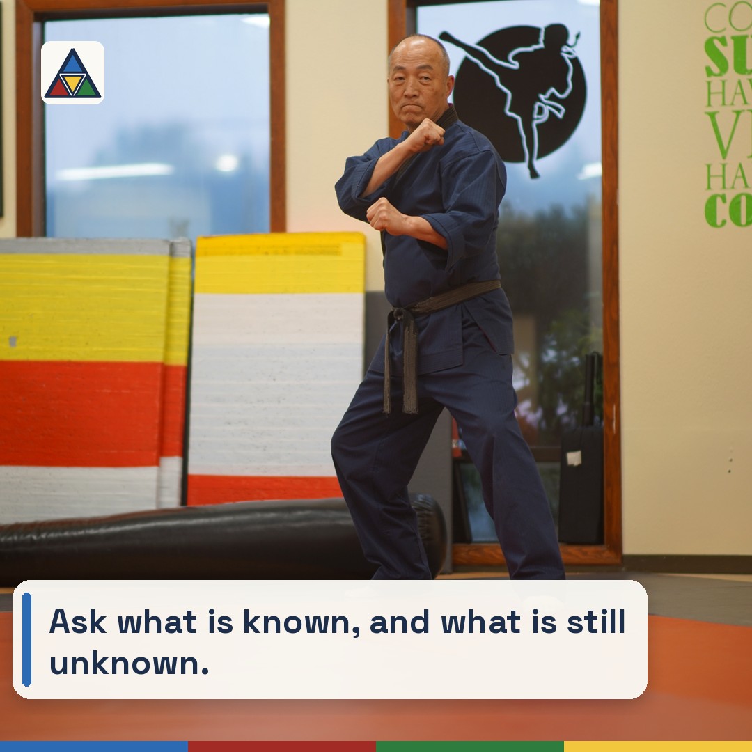 Grand Master Won Kuk Kim holding a stance in the wide academy room
